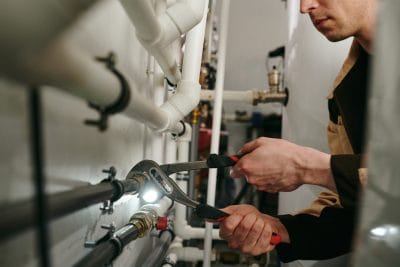 Technician inspecting commercial plumbing pipes in Diamond Bar