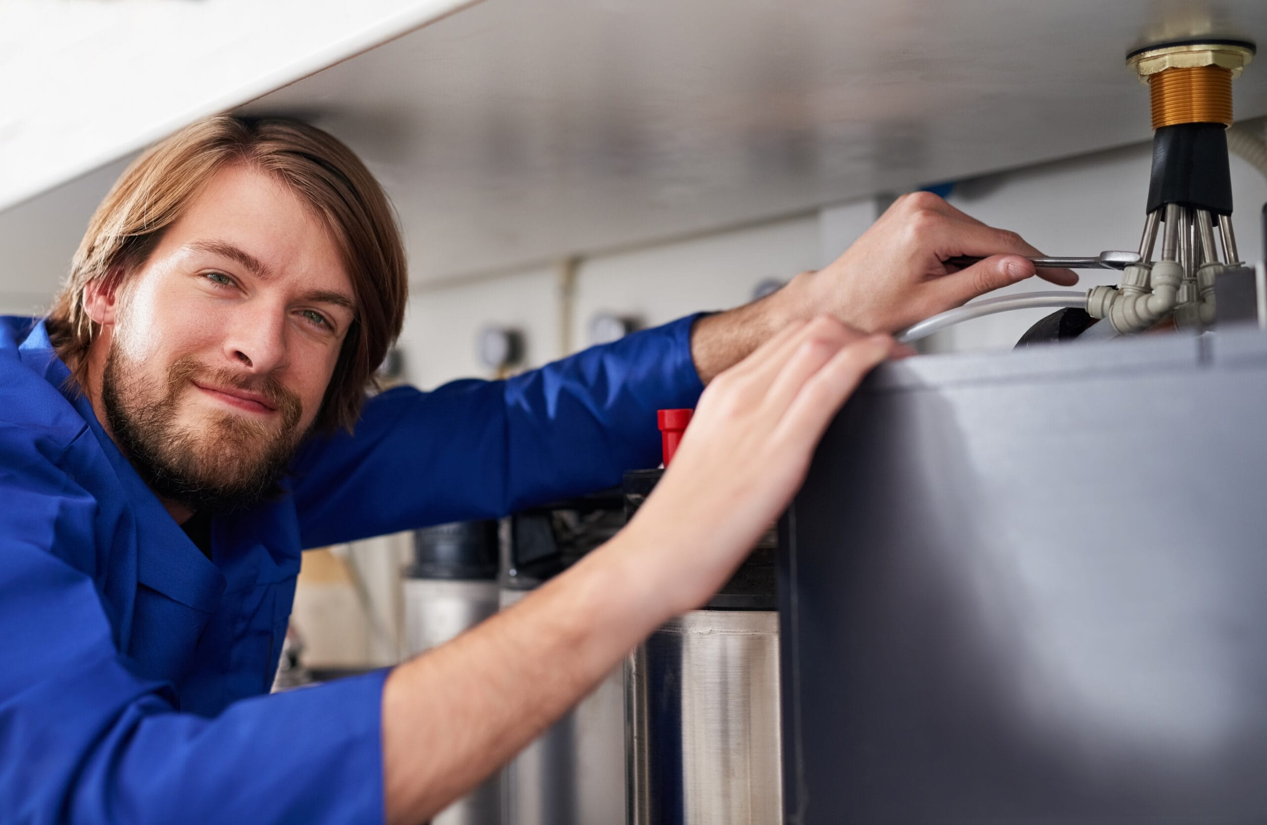Technician servicing a residential water heater tank in Diamond Bar